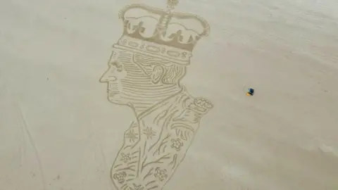 PA Media King Charles drawn in sand