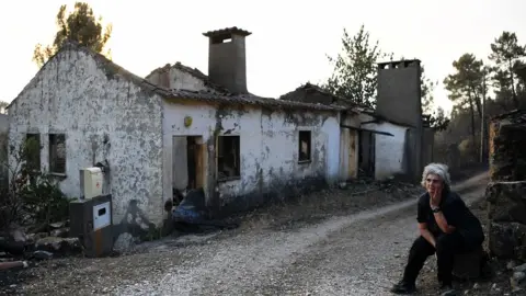 Getty Images Maria Manuela Mendes sits beside her burnt house in Mendeira, near Cernache do Bonjardin, on June 19, 2017