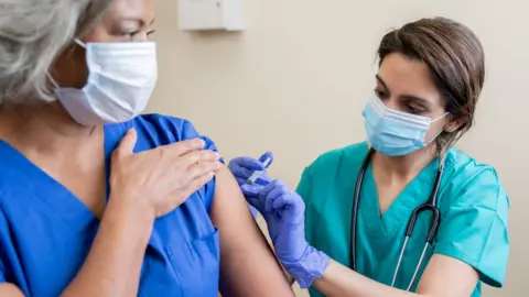 Getty Images NHS staff being vaccinated