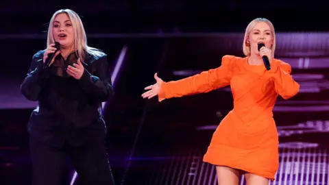 Reuters Lithuania's Monika Linkyė (right) with British backing singer Nicola Lambrianos on stage at Eurovision