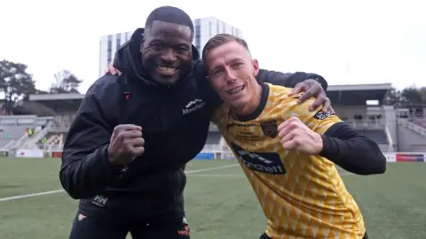 Getty Images Maidstone manager George Elokobi and midfielder Sam Corne celebrate victory over Stevenage