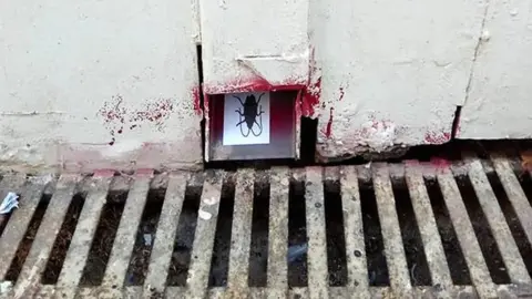 ReCompulsive Behaviours Image of a cockroach confronts Greeks from an Athenian drain