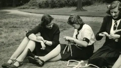 The Guide Association Queen Elizabeth II knotting at Frogmore. Patricia Hobbs is on the Princess left