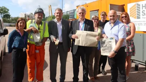 University of Portsmouth a group of eight people holding items like old newspapers