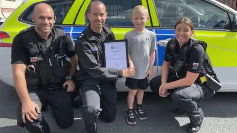 North Wales Police Sunny receives his bravery award from with PC Gary Yarwood, Insp Luke Hughes and PC Emma Horne