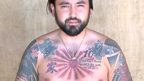 Topless man with tattoos