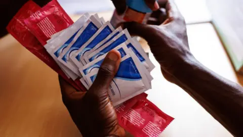 Lubrication, condoms, and PrEP are given to a transgender sex worker at a LGBTQ sympathetic clinic on April 17, 2023 in Kampala, Uganda