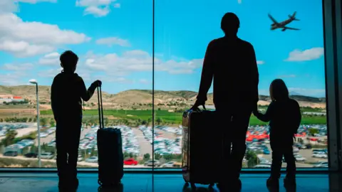 Getty Images Silhouettes of people at an airport