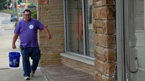 BBC Clint Barta carrying a bucket