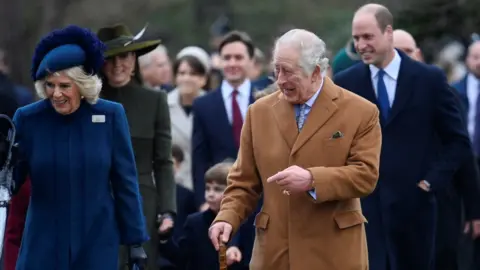 Reuters King Charles III walks along side the Queen Consort after attending the Royal Family's Christmas Day service in Sandringham