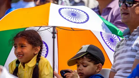 PA Media Young fans take some shade in the Oval's stands during day four of the ICC World Test Championship Final match between India and Australia