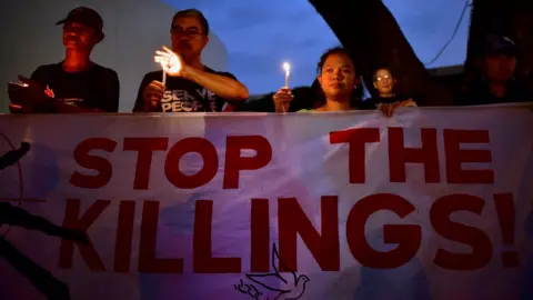 Getty Images Protesters hold a sign that reads 'Stop the Killings'