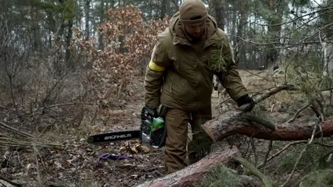 People digging trenches in a forest near Kyiv to block a Russian advance