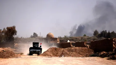 EPA Iraqi military vehicles advance towards the centre of Tal Afar, northern Iraq (23 August 2017)