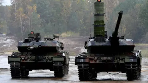 In this file photo taken on October 13, 2017 soldiers in Leopard 2 A7 main battle tanks of the German armed forces Bundeswehr drive in the context of an informative educational practice "Land Operation Exercise 2017" at the military training area in Munster, northern Germany.