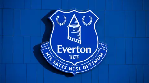 The blue and white Everton badge on the side of Goodison Park
