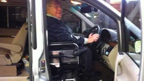 James Porteous James sitting in his wheelchair at the steering wheel of his car