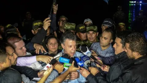 AFP/Getty Images Colombian President Juan Manuel Santos (centre) answers questions from reporters