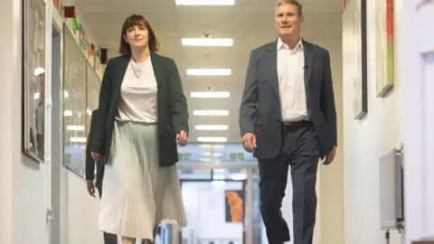 PA Media Bridget Phillipson and Keir Starmer walk through school hallway