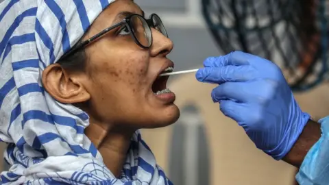 EPA A swab sample is collected from a woman in Mumbai.