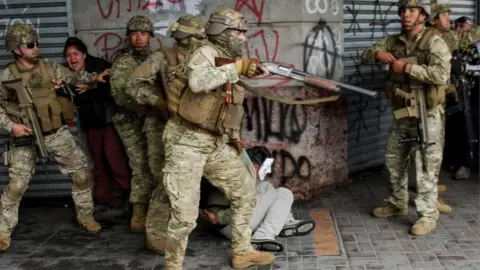 Reuters Security forces detain a demonstrator during anti-government protests, in Concepcion, Chile October 26, 2019.