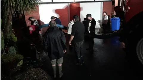 Eglinton Community Resilience Group residents pumping out flood water in eglinton village