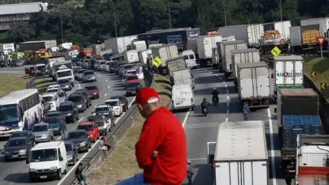 AFP Brazilian truck drivers block the Regis Bittencourt road, 30 kilometres from Sao Paulo, during a strike to protest rising fuel costs in Brazil, on May 24, 2018.