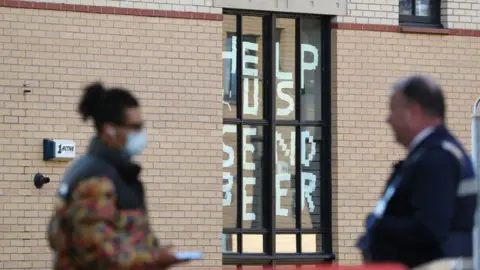 PA Media A sign saying "help us, send beer" at Murano Street Student Village in Glasgow, where Glasgow University students are being tested at a pop up test centre.