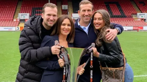 JE3 Foundation Justin Edinburgh, second right, wife his son Charlie, wife Kerri and daughter Cydnie, celebrating Leyton Orient's championship win in the National League in 2018-19