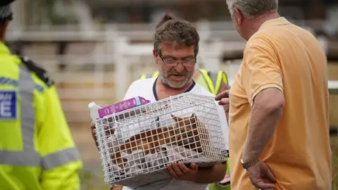 PA Media A resident holding a cat in a carrier