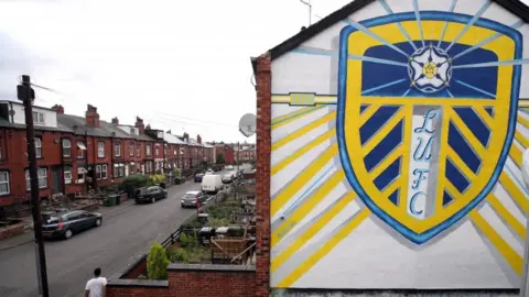 PA Media A Leeds crest on the side of a house