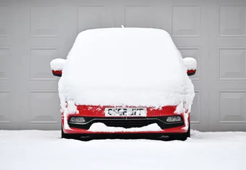 Ben Stansall / AFP Car covered in snow