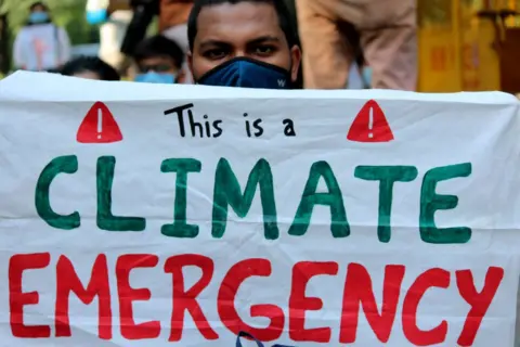 Getty Images Demonstrators hold placards take part in a protest against climate change in India