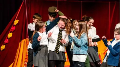 Longborough Festival Opera Children on stage taking part in an opera workshop