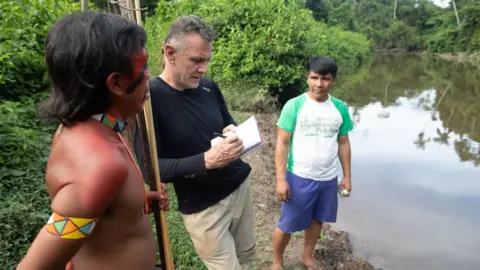 Getty Images Dom Phillips talking to two indigenous men in Roraima State, Brazil in 2019