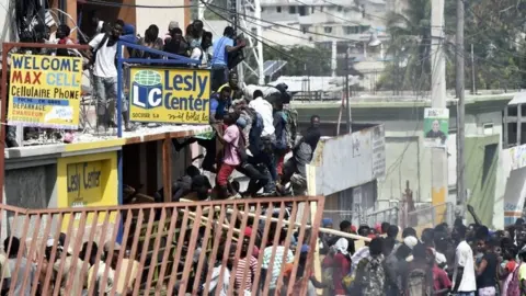 AFP People loot shops in Delmas, a commune near Port-au-Prince, during protests against the rising price of fuel, on July 8, 2018.