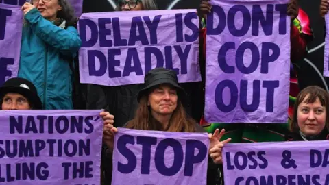 Getty Images Members of climate action protest group Scientist Rebellion hold signs during a demonstration in Glasgow on the side lines of the COP26 UN Climate Change Summit