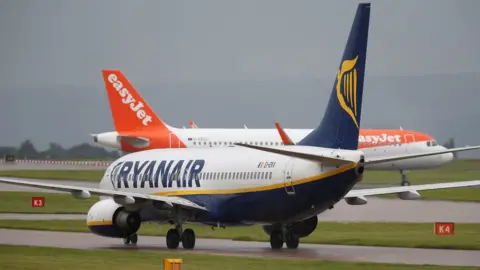 Reuters A Ryanair aircraft taxis behind an easyJet aircraft at Manchester Airport