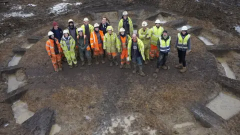 Oxford Archaeology East Archaeologists standing in a roundhouse at Warboys dig