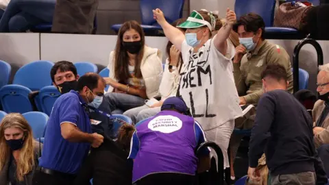 Reuters Security remove protesters from the crowd during the Australian Open final