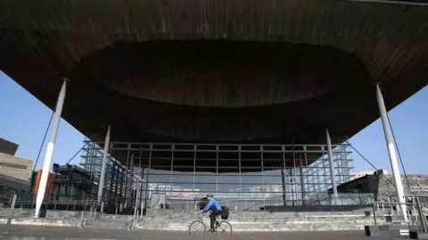 Getty Images A cyclist riding past the Senedd in Cardiff Bay