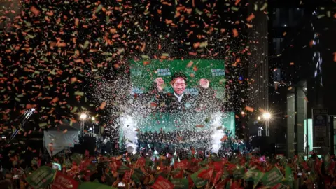 BBC Confetti flies over the stage and crowd as Taiwan's Vice President and presidential-elect from the Democratic Progressive Party (DPP) Lai Ching-te and his running mate Hsiao Bi-khim speak to supporters at a rally at the party's headquarters on January 13, 2024 in Taipei, Taiwan.