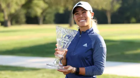 American Danielle Kang smiles as she holds up the trophy for winning the Marathon Classic
