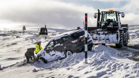 PA Media Car being dug out of snow with the help of a tractor during Storm Arwen