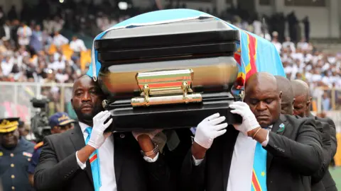 Reuters Pallbearers carry the casket with the remains of Etienne Tshisekedi, former Congolese opposition figurehead who died in Belgium two years ago, at a mourning ceremony at the Martyrs of Pentecost Stadium in Kinshasa on 31 May.
