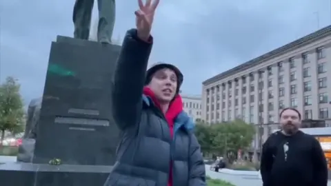 BBC Artyom Kamardin holds up the peace sign in Triumfalnaya Square on an overcast Moscow day