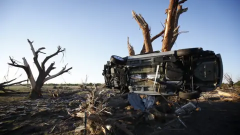 Getty Images A car wedged next to a tree after OKlahoma tornado - 25 May 2013
