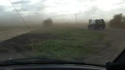 Mud blown across a road in Cambridgeshire
