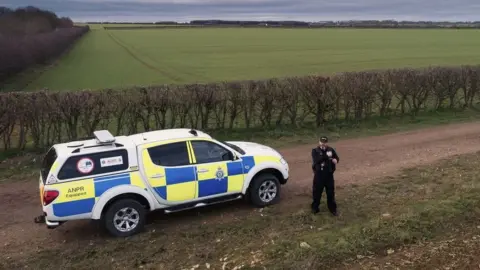 Lincolnshire Police Police officer standing next to patrol car