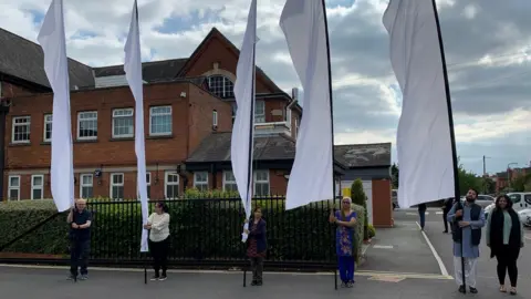 BBC/Toby Friedner A group of people holding scrolls in Wolverton, Buckinghamshire